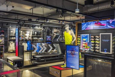 Modern spor mağazasının içinde spor ayakkabıları sergilenen koşu bandında çalışan mankenler var. - New York. ABD