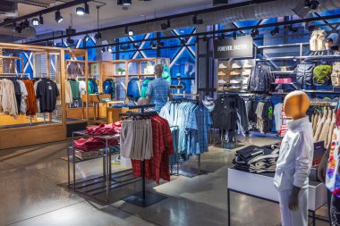 Puma mağazası bölümünde erkek spor kıyafetleri sergileniyor. Ahşap raflar ve parlak ışıklandırmayla. - New York. ABD. 