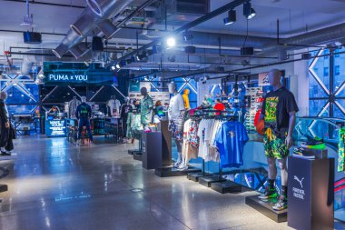 Modern Puma mağazasının içinde endüstriyel tavan ışıkları altında spor giyimli mankenler var. - New York. ABD. 