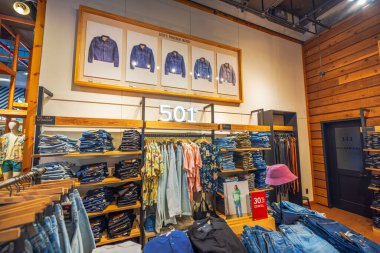 Levis mağazasının içinde istiflenmiş kot pantolonlar, ahşap raflar ve klasik kot ceketler var. - New York. ABD. 