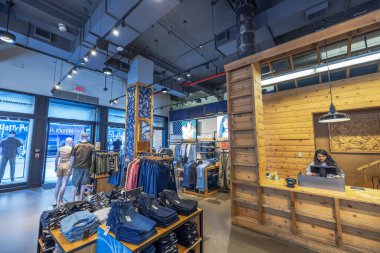 Levis 'ın içi ahşap tezgahta kasiyer, raflarda kot pantolon ve girişe yakın mankenlerle dolu. - New York. ABD.