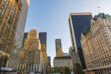 Manhattan şehir merkezindeki güneş ışığını yansıtan gökdelenler, tarihi ve modern binalar çarpıcı bir şehir manzarası yaratıyor. - New York. ABD. 
