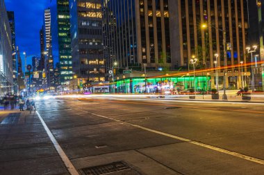 Night view of Fifth Avenue in New York City with light tracers from car headlights, modern skyscrapers and illuminated streets. New York. USA. clipart