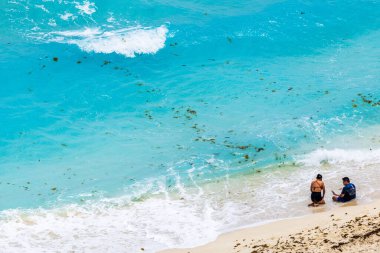 Karayipler 'in kumlu sahillerinde yüzeye çıkan deniz yosunlarıyla ve dalgalar yavaşça kıyıya ulaşıyor. Cancun. Meksika. 