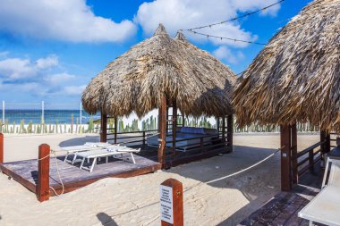 Ahşap güverteli, güneşli şezlonglu ve Karayip deniz manzaralı bir sahil kabini.. 