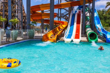 Renkli slaytlarla dolu bir su parkı, su sıçratma havuzu, çocukların eğlenmesi, şişme tüp ve tropikal çevre.. 