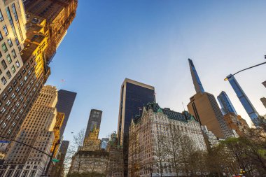 New York 'ta gökdelenler ve tarihi binalar sıcak akşam güneşiyle mavi gökyüzüne karşı. - New York. ABD.