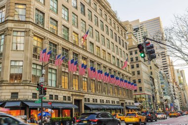 New York 'ta Beşinci Cadde' de Amerikan bayraklı tarihi bina trafiği ve yayaları var. - New York. ABD.