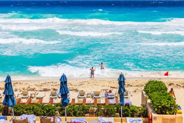 Karayip Denizi 'nin turkuaz dalgaları kumlu sahilleri güneş pansiyonları, kapalı şemsiyeler ve suyun tadını çıkaran insanlarla yıkıyor. Meksika mı? Cancun..