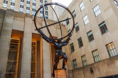 Bronz Atlas heykeli, Manhattan 'daki Rockefeller Center' da Art Deco binalarının önünde bir armiler küre tutuyor. - New York. ABD.