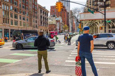 Doğu 86. Cadde 'de ve New York' ta 3. Cadde 'de yayalar, arabalar, trafik ışıkları ve binalarla dolu bir kavşak. - New York. ABD.