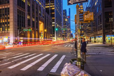 Gece New York 'ta Beşinci Cadde ile Batı 45. Cadde' nin kesiştiği yerde ışık yolları, trafik ve aydınlatılmış binalar var. - New York. ABD.