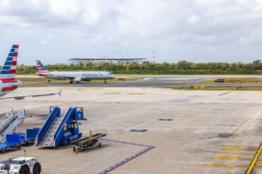 Amerikan Hava Yolları 'nın beyaz bulutlu mavi gökyüzüne karşı havaalanı pistinde taksicilik yapıyor. Cancun. Meksika. 