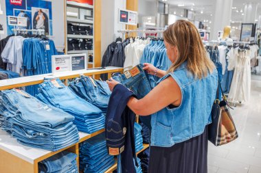 Macys moda departmanında Levis kot pantolon seçen bir kadının yakın görüntüsü. - New York. ABD.
