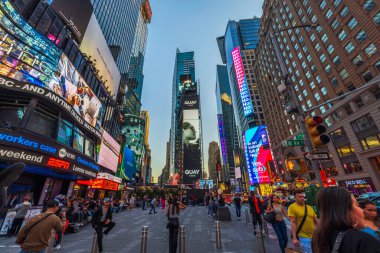 Times Meydanı, alacakaranlıkta aydınlanmış reklam panoları ve gökdelenler arasında yürüyen insanlarla dolu. - New York. ABD. 