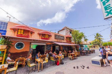 Willemstad Caddesi 'nde açık bir kafe, sömürge binaları, yemek yiyen insanlar, ahşap masalar, tropikal bitkiler ve kaldırımda güvercinler. Willemstad. Curacao.