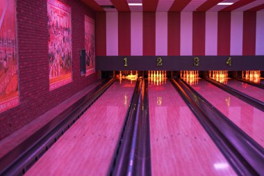 Parlayan iğneleri, kırmızı ışıkları ve duvarlarında antika posterleri olan boş bowling salonunun renkli manzarası.. 