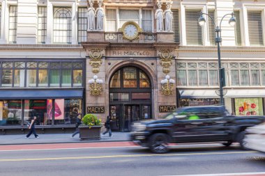 Macy 'nin mağazasının tarihi girişi altın rengi detaylar, heykeller bahar günü geçen bulanık arabalar. - New York. ABD.