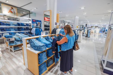 Levi 'nin kot pantolonu için modern moda mağazasında kadın alışverişi yapıyor. - New York. ABD.