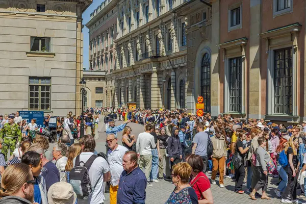 İsveç Ulusal Günü 'nü Stockholm' deki Kraliyet Sarayı yakınlarında geleneksel geçit töreniyle kutlayan bir kalabalık. İsveç. 