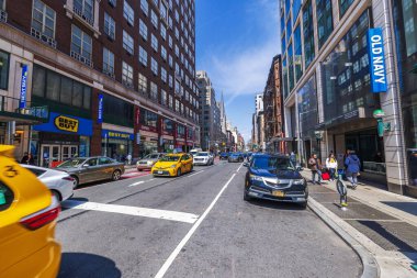 Best Buy, Old Navy mağazaları, sarı taksiler ve güneşli bir günde yürüyen insanlarla dolu Manhattan caddesi. - New York. ABD.