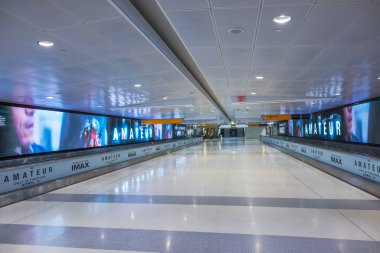 JFK havaalanındaki boş koridorda IMAX film posterleri ve çıkış kapılarına giden yol aydınlatılmış. - New York. ABD.