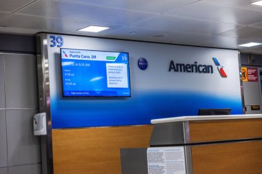 American Airlines 'ın JFK havaalanındaki giriş kapısı Punta Cana uçuşunu ekranda gösteriyor. - New York. ABD. 