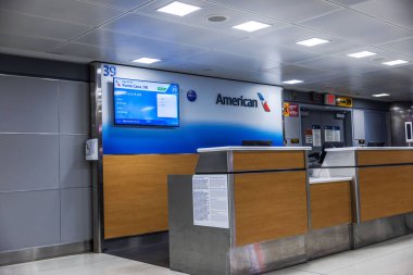 American Airlines masası ve Punta Cana uçuş bilgileriyle birlikte JFK Havaalanı 39 no 'lu uçuş kapısı elektronik ekranda. - New York. ABD. 