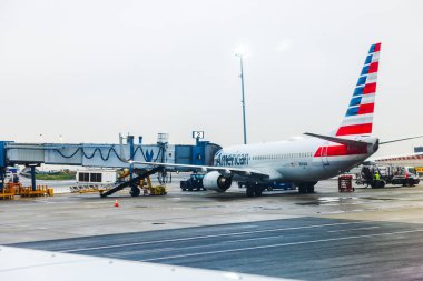 Bulutlu bir sabah uçuşu sırasında JFK Havaalanı 'ndaki yolcu jetine bağlı Amerikan Havayolları uçağı. - New York. ABD.