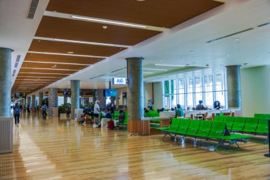 Punta Cana Havalimanı 'nın giriş kapısında yeşil sandalyeli ve modern iç mekânlı yolcular bekliyor. Punta Cana. Dominik Cumhuriyeti. 