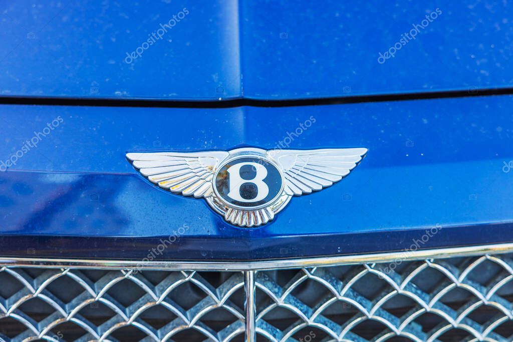 Close up view of Bentley emblem on blue luxury car hood with chrome front grille. Miami Beach. USA.