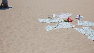 Kırışık çizgili havlular, abur cuburlar ve güneş kremi Miami Sahili 'nde öğlen güneşinin altında kumlara saçılmış. Miami Plajı. ABD. 