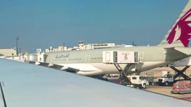 Katar Havayolları uçakları servis kamyonları ve kargo operasyonlarıyla havaalanı kapısında. - New York. ABD. 05.31.2025.