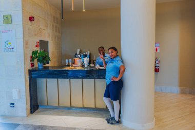 Dost canlısı otel çalışanları Breathless Punta Cana Resort lobisinde şampanya bardaklarıyla içki tezgahında poz veriyorlar. Punta Cana. Dominik Cumhuriyeti. 