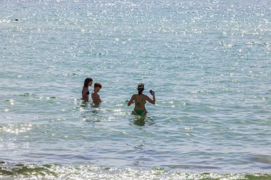 Sıcak Atlantik Okyanusu 'nda yıkanan turistler Miami Sahili' nde parlak güneş yansımalarıyla. Miami Plajı. ABD. 
