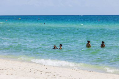 İnsanlar zümrüt yeşili Atlantik Okyanusu 'nda, Miami Sahili' nin beyaz kum kıyısında, parlak güneş ışığında yüzüyorlar. Miami Plajı. ABD. 