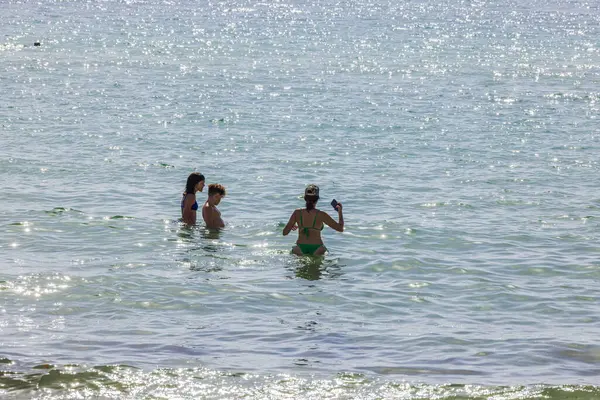 Sıcak Atlantik Okyanusu 'nda yıkanan turistler Miami Sahili' nde parlak güneş yansımalarıyla. Miami Plajı. ABD. 