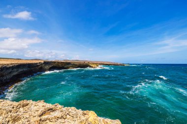 Kayalıklara çarpan berrak mavi suları ve köpüklü dalgalarıyla Rocky Karayip kıyıları. Aruba.