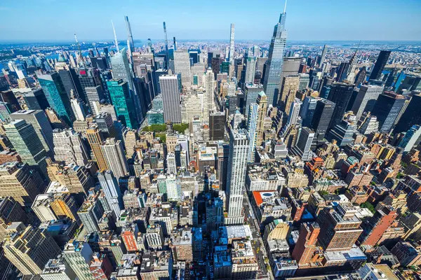 Empire State Binası 'nın gölgesi Manhattan şehir merkezindeki gökdelenlere parlak güneş ışığı altında düşüyor. - New York. ABD.