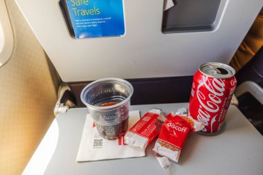 Amerikan Havayolları 'nın tepsisindeki kahvaltısını boş Biscoff ambalajları, Coca Cola kutusu ve bardakla bitirdim. - New York. ABD. 