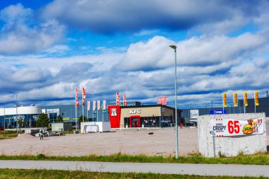 Bulutlu bahar gökyüzünün altında bayrak ve bayrak mağazaları yakınında KFC restoranı.