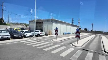 Kos Adası 'ndaki havaalanından kalkan otobüs, kavşak, Food Port Cafe ve Europcar ofisi manzaralı. Kos. Yunanistan. 