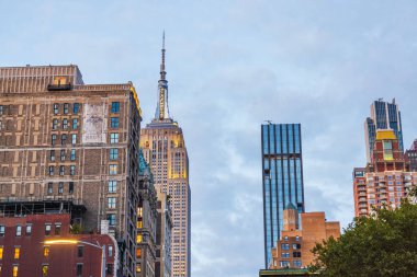 Günbatımında New York 'taki yerleşim ve ofis binalarının arka planında Empire State Binası. - New York. ABD. 