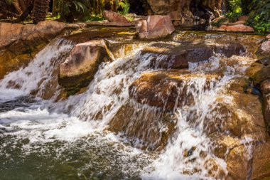 Yapay şelale, otelin bahçesinde kayalar ve akan su. Las Vegas mı? ABD.