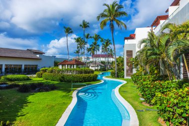 Dominik Cumhuriyeti 'nde Atlantik Okyanusu yakınlarında palmiye ağaçları ve tropikal bahçesi olan bir tatil havuzu. Punta Cana.