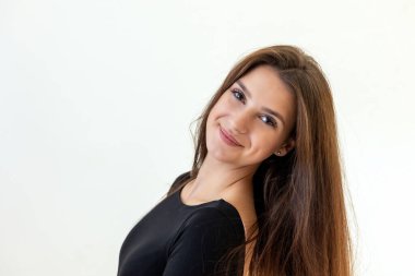 Gülümseyen çekici kız arka planda poz veriyor. Yatay olarak. 