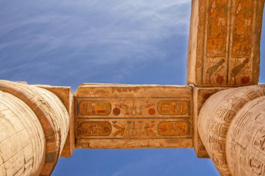 Karnak tapınağında renkli hiyeroglifli sütunlar. Arka planda mavi gökyüzü, Lüksör, Mısır. Yatay olarak