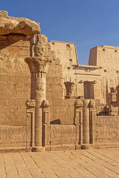 Edfu 'daki eski Mısır tapınağı Horus. Yüksek duvarda tanrıların oyulmuş görüntüleri görülebilir. Dikey. 