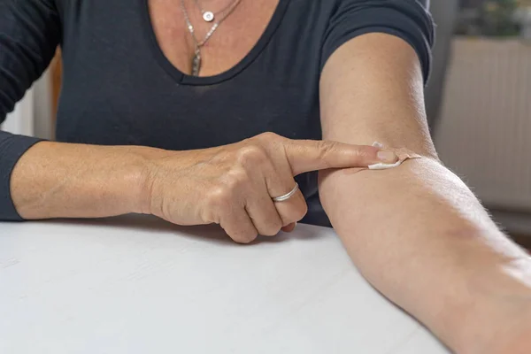 Woman holds a adhesive plaster on her hand with her finger.