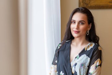 İçerde poz veren koyu renk saçlı güzel bir kızın ön manzara portresi. Yatay olarak. 